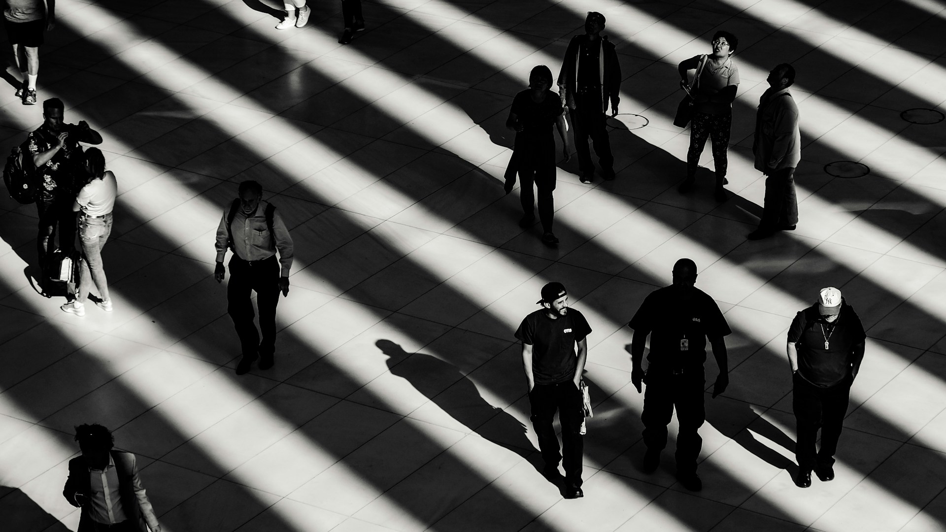 People crossing a hall under striped light